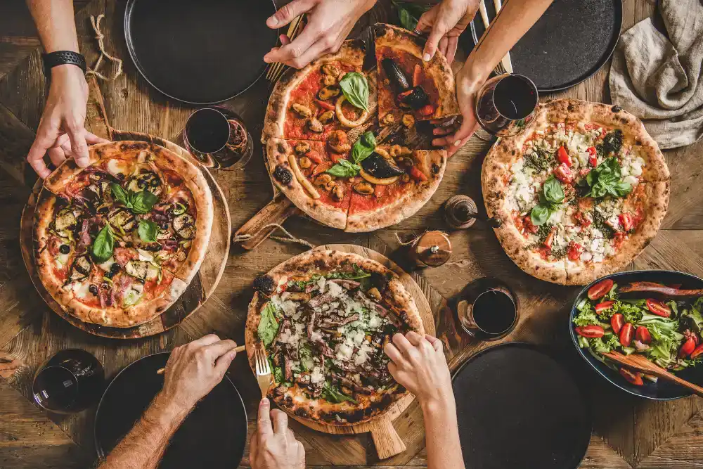a group of people eating pizzas